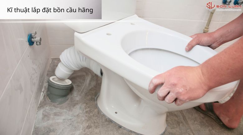 Thợ đang lắp bồn cầu tiêu chuẩn của hãng