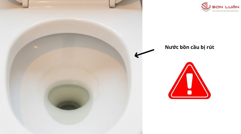 Ảnh cận cảnh lòng bồn cầu bị rút nước (Siphon bị hút), minh họa dấu hiệu lỗi ống thoát hơi.